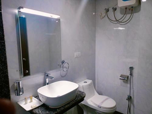 La salle de bains est pourvue d'un lavabo, de toilettes et d'un miroir. dans l'établissement Hotel Vip Square, à Purî