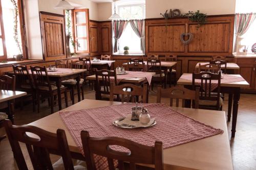 ein Esszimmer mit Tischen, Stühlen und Fenstern in der Unterkunft Gasthof Kampenwand Aschau in Aschau im Chiemgau
