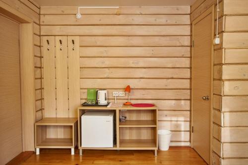 a kitchen with wooden walls and a counter with a refrigerator at Altay Park Hotel Podgoritsa in Manzherok