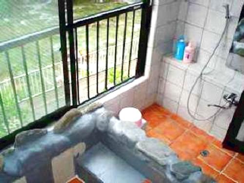 La salle de bains est pourvue d'une baignoire en face d'une fenêtre. dans l'établissement Shima Onsen Ichigekan, à Nakanojo