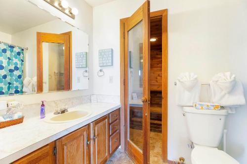 a bathroom with a toilet and a sink and a mirror at Hi-Tide Resort in Moclips