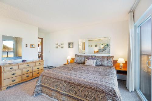 a bedroom with a bed and a dresser and a mirror at Hi-Tide Resort in Moclips