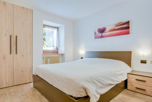 1 dormitorio con 1 cama grande y armario de madera en Cesa Crepaz piccolo, en Canazei