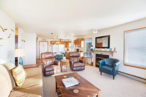 a living room with leather furniture and a fireplace at Hi-Tide Resort in Moclips
