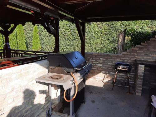a outdoor grill with a tv and a table at Ponty-Poronty Vendégház in Nagybaracska