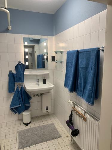 a bathroom with blue towels and a sink at Lilli-Marleen 1-23 Wurster-Nordsee-Küste in Schottwarden