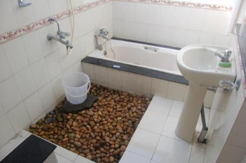 a bathroom with a sink and a toilet and a tub at SAMBODHI YOGA RETREAT in Alleppey