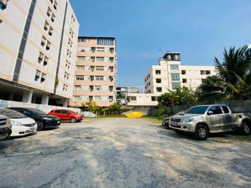 a parking lot with cars parked in front of tall buildings at City Residence in Bangkok