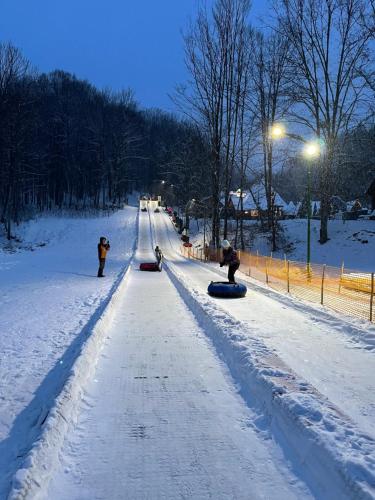 a snowy road with people on snowboards on it at Oasis Karpat in Polyana
