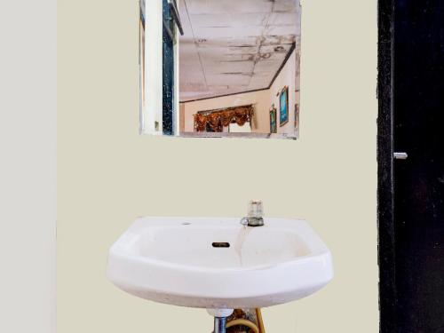 a white sink in a bathroom with a mirror at Hotel Mataram Cipanas Syariah Mitra RedDoorz in Pasakon 1