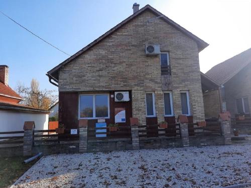 a brick house with a sign in front of it at Horgász-Lak vendégház in Nagybaracska