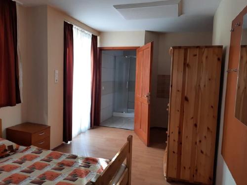 a bedroom with a bed and a door to a bathroom at Horgász-Lak vendégház in Nagybaracska