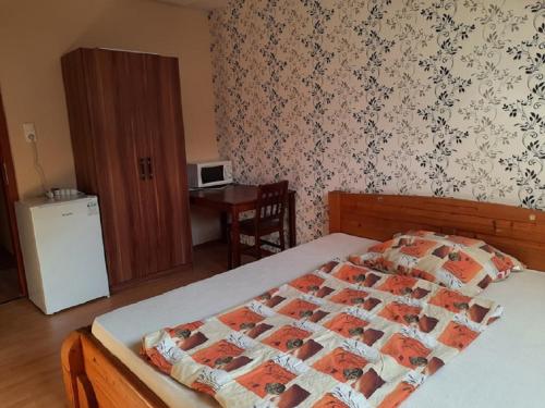a bedroom with a bed and a table and a desk at Horgász-Lak vendégház in Nagybaracska