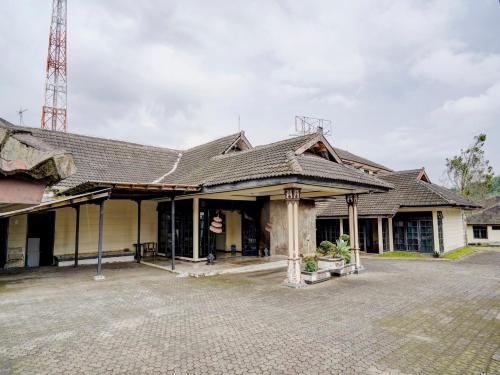 an old house with a shingled roof at Hotel Mataram Cipanas Syariah Mitra RedDoorz in Pasakon 1