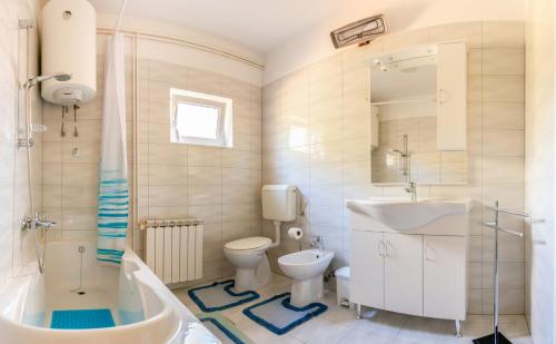 a bathroom with a toilet and a sink and a tub at Apartment Maria in Malinska