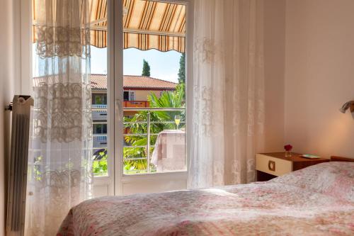 a bedroom with a bed and a large window at Apartment Maria in Malinska
