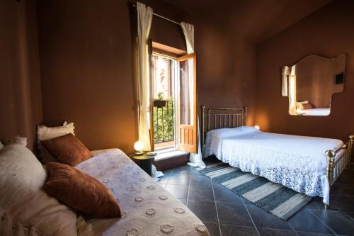 een slaapkamer met 2 bedden en een raam bij Le Stanze del Cioccolato in Modica