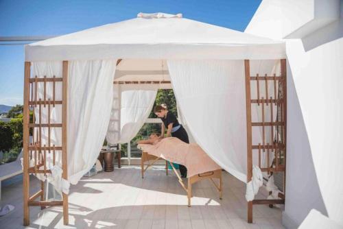 a woman is under a white canopy at Anastasia Hotel Stalis in Stalida