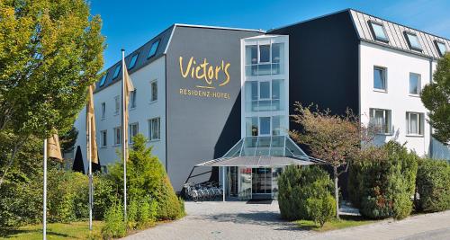 een gebouw met een bord dat staat voor een maagdelijk verblijfscentrum bij Victor's Residenz-Hotel München in Unterschleißheim