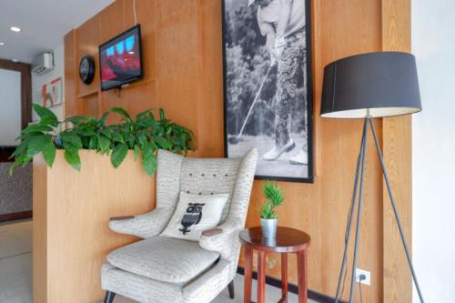 a living room with a chair and a lamp at Sans Hotel Ekkon Yogyakarta by Reddoorz in Ngabean