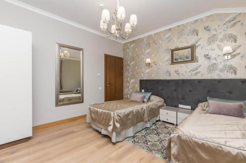 1 dormitorio con 2 camas y espejo en Ladozhskaya Usadba, en Niemelanhovi