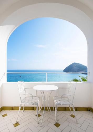 a table and chairs in a room with a view of the ocean at Apollon Club & Thermal Spa in Ischia