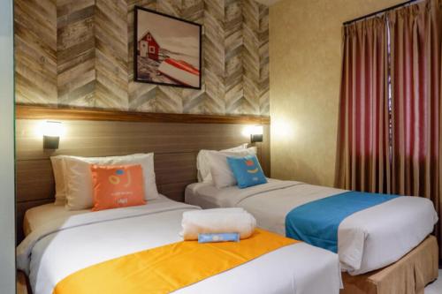 a hotel room with two beds in a room at Sans Hotel Ekkon Yogyakarta by Reddoorz in Ngabean