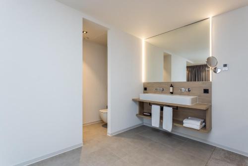 a bathroom with a sink and a mirror at Hotel de Rousch - 4 sterren Superieur in Heerlen