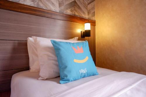 a blue pillow sitting on top of a bed at Sans Hotel Ekkon Yogyakarta by Reddoorz in Ngabean