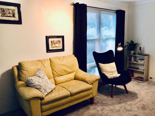 a living room with a couch and a chair at Jen's Escape Albany in Albany