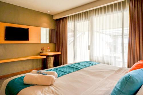 a hotel room with a bed and a window at Sans Hotel Ekkon Yogyakarta by Reddoorz in Ngabean