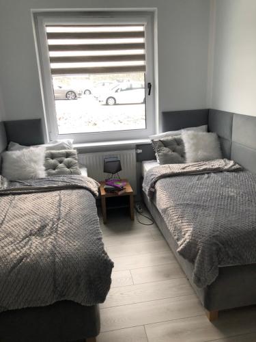 a bedroom with two beds and a window at Apartament Happiness in Jelenia Góra