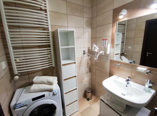 y baño con lavadora y lavamanos. en Apartament przy hotelu Aquarius en Kołobrzeg