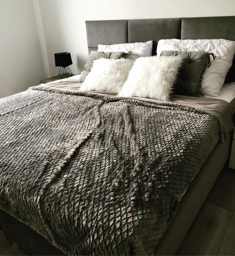 a large bed with white pillows on top of it at Apartament Happiness in Jelenia Góra