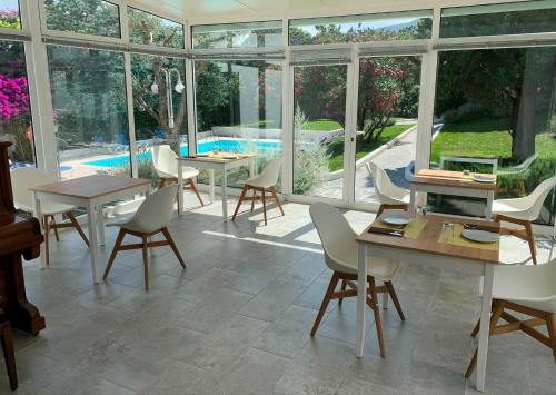 a conservatory with tables and chairs and a pool at Hotel Misty in Cadaqués