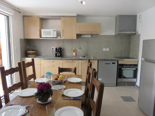 a kitchen with a wooden table with chairs and a dining room at Verdon Vacances in Saint-André-les-Alpes