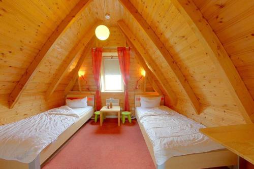 a bedroom with two beds in a wooden attic at Strandvogt 3 NT3 in Dorum-Neufeld
