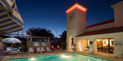 a building with a clock tower next to a swimming pool at Gateway Studio Suites in Sierra Vista
