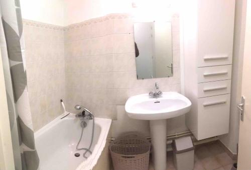 a white bathroom with a sink and a tub and a sink at Studio BRITTANY in Chambéry