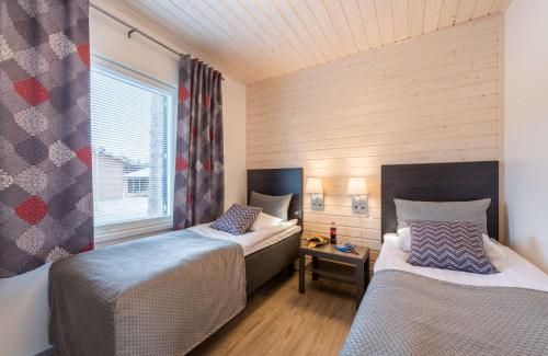 una habitación con dos camas y una ventana en Holiday Club Kuusamon Tropiikki Superior Apartments, en Kuusamo