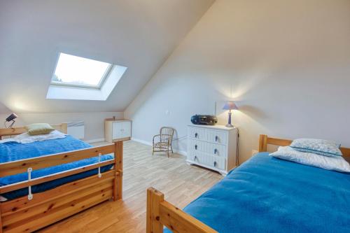 een slaapkamer op zolder met 2 bedden en een dakraam bij Maison Charles - plage à 800 m in Pléneuf-Val-André