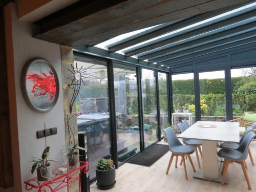 - une salle à manger avec des portes en verre, une table et des chaises dans l'établissement chambre d’hôte naturiste ou pas, à Miniac-Morvan