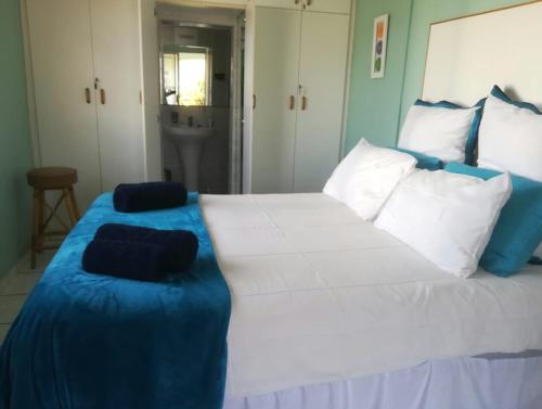 a large white bed with blue and white pillows on it at Mountainia Inn in Worcester