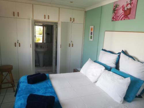 a bedroom with a white bed with blue and white pillows at Mountainia Inn in Worcester