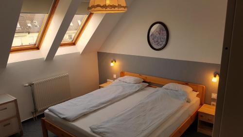 een slaapkamer met 2 bedden en een klok aan de muur bij AAA-Apartment 2 in Balatonfüred