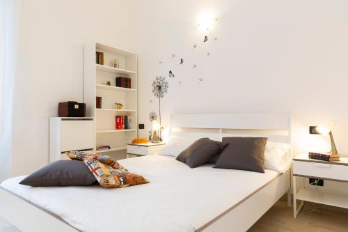 a white bedroom with two beds and a desk at Affori 4ever - 2 bedrooms in Milan