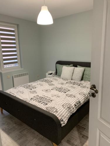 a bedroom with a bed with a black and white comforter at Апартамент Сливен in Sliven