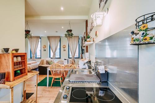 a kitchen with a sink and a living room at La villa des souhaits in Honfleur