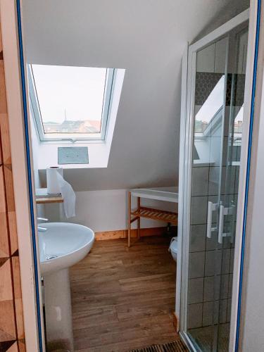 La salle de bains est pourvue d'une fenêtre, d'un lavabo et d'une douche. dans l'établissement La villa des souhaits, à Honfleur