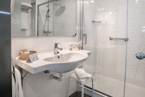 a white bathroom with a sink and a shower at Hotel La Cala Finestrat in Cala de Finestrat